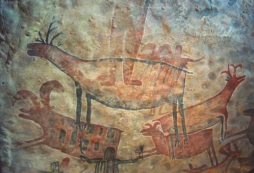 Pintura rupestre con figuras de ciervos y humanos en una escena de caza, arte prehistórico en una cueva