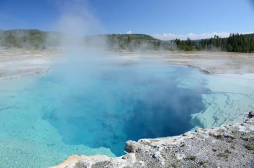 Piscina termal con aguas azules y vapor en Yellowstone