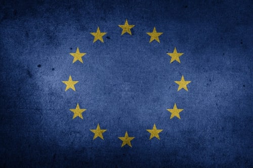 Bandera de la Unión Europea: doce estrellas doradas en círculo sobre fondo azul texturizado