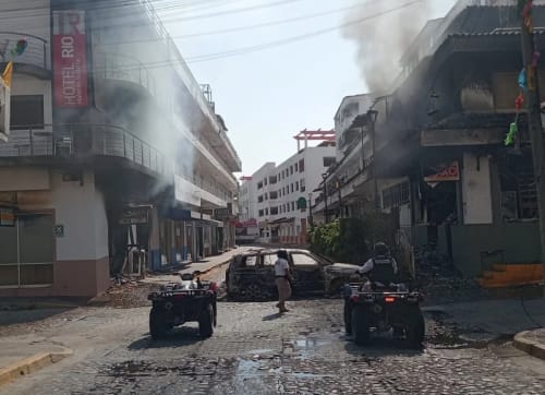 Calle con vehículos incendiados y presencia de fuerzas de seguridad tras un operativo en Jalisco