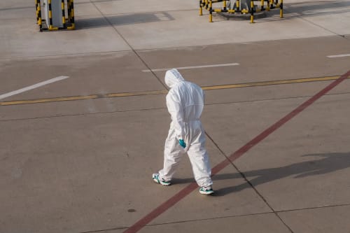 Persona con traje de protección en zona de cuarentena