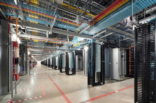 Interior de un centro de datos con filas de servidores y cableado de red