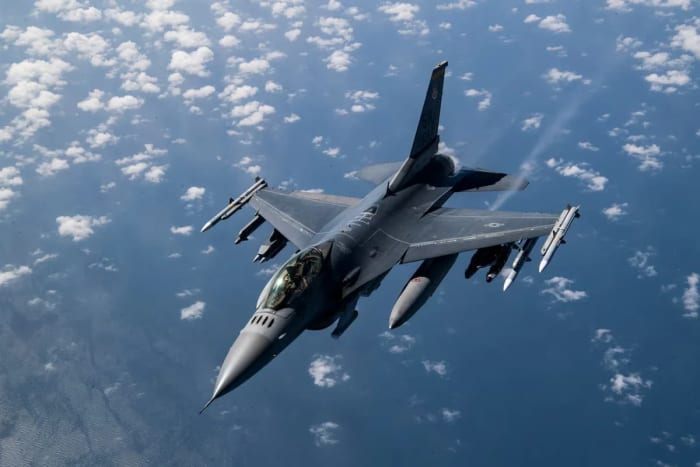Técnicos inspeccionan el tren de aterrizaje de un F-16 Fighting Falcon en una base aérea