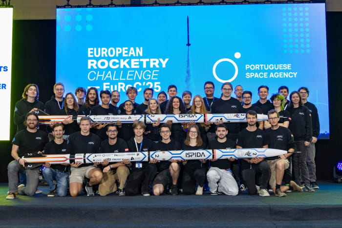 Integrantes del equipo aeroespacial de Graz posan sonrientes junto a sus cohetes tras una jornada de competición y pruebas exitosas