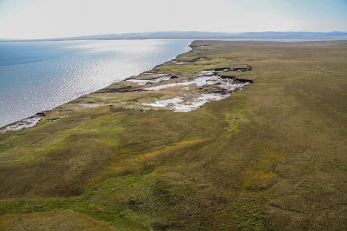 Vista del océano Ártico con bloques de hielo flotando y costas parcialmente descongeladas