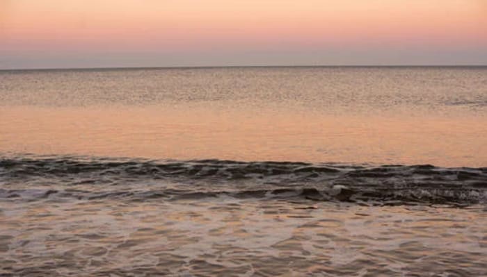 Olas rompiendo cerca de la costa con tonos azul oscuro y espuma blanca, representando la acidificación del océano