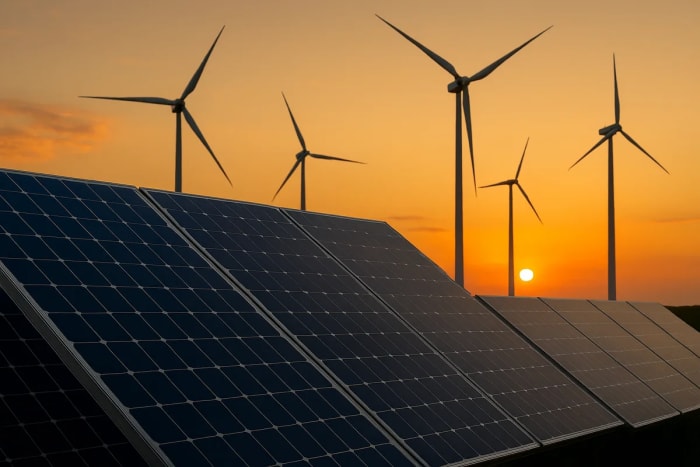 Paneles solares y aerogeneradores al atardecer en un paisaje de energías renovables