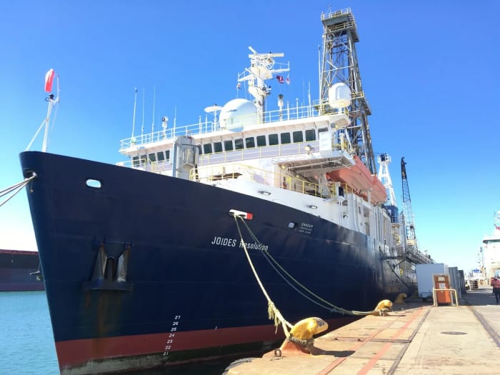 Buque de gran tamaño atracado en puerto y asegurado con amarras bajo un cielo despejado