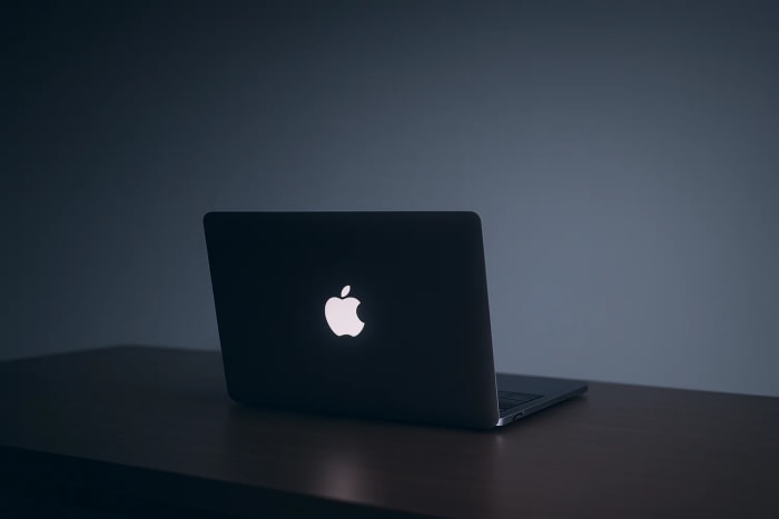 MacBook con el logo iluminado sobre una mesa