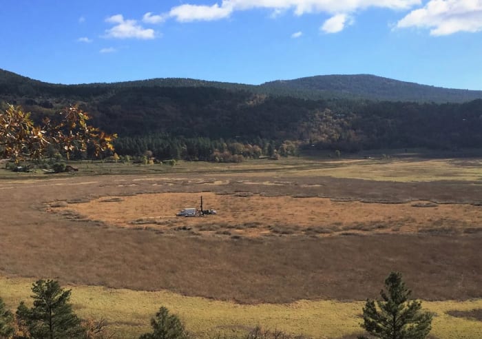 Investigadores perforando un núcleo de sedimento en el lago Stoneman con equipo de muestreo