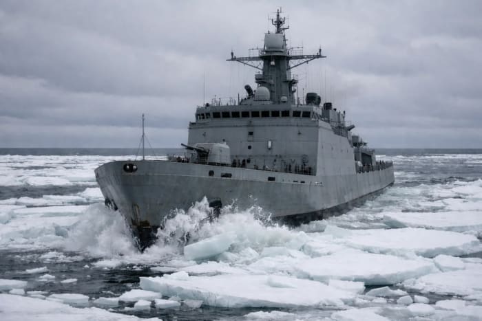 Buque militar avanzando entre bloques de hielo en aguas del Ártico