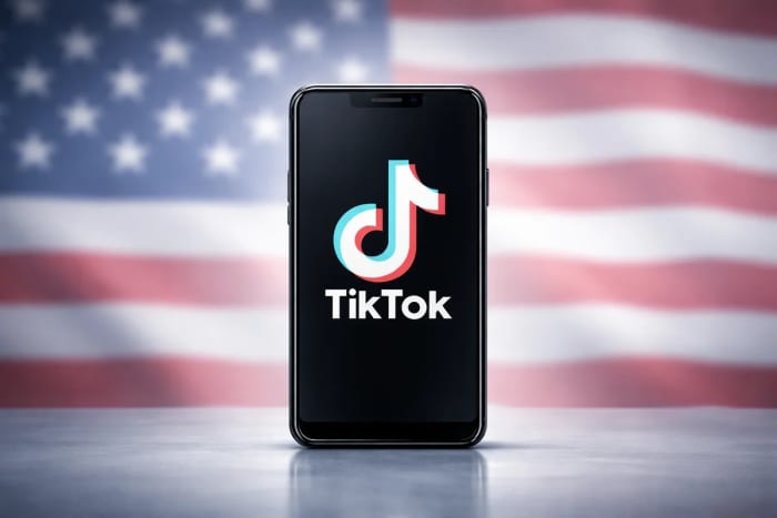 Smartphone con el logotipo de TikTok frente a una bandera de Estados Unidos desenfocada