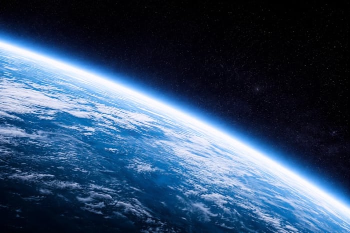 Vista del horizonte terrestre desde el espacio con la curvatura del planeta y la atmósfera iluminada