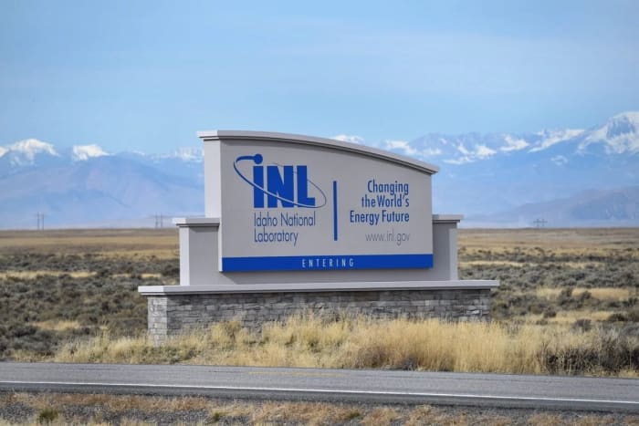 Cartel de entrada del Idaho National Laboratory en un paisaje árido con montañas al fondo