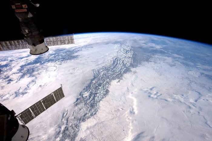 Tierra nevada vista desde el espacio con paneles solares en primer plano