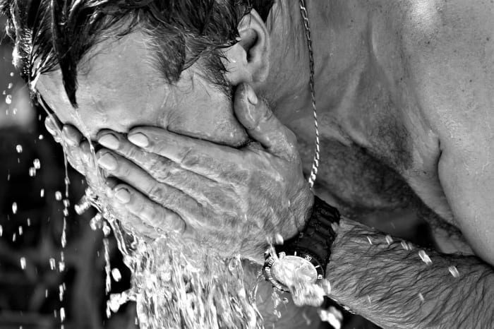 Persona refrescándose con agua en un día caluroso