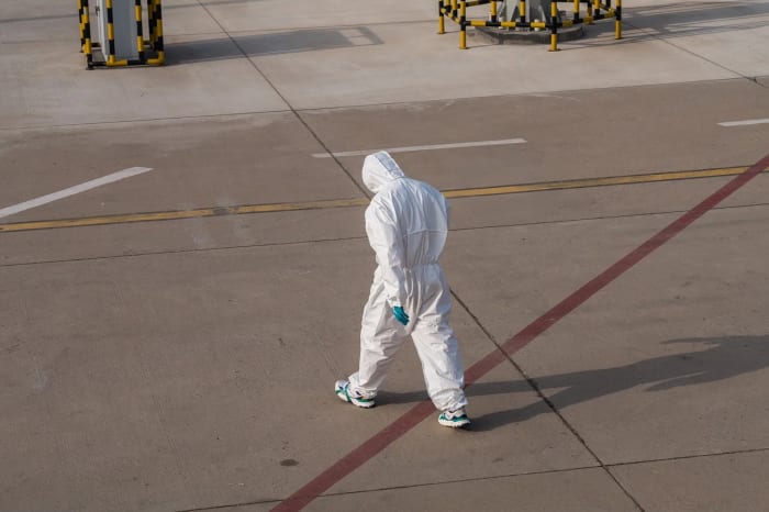 Persona con traje de protección en zona de cuarentena