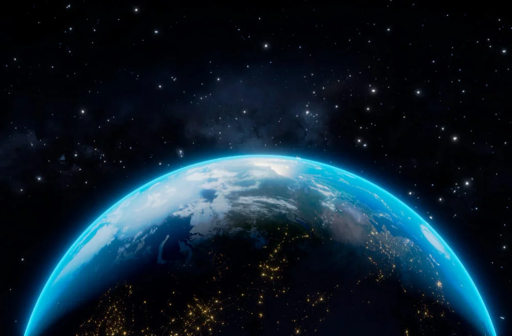 Imagen satelital de la Tierra desde el espacio mostrando la curvatura del planeta y la línea entre la luz del día y la oscuridad de la noche, en el contexto de un artículo que explora las consecuencias de la detención de su rotación.