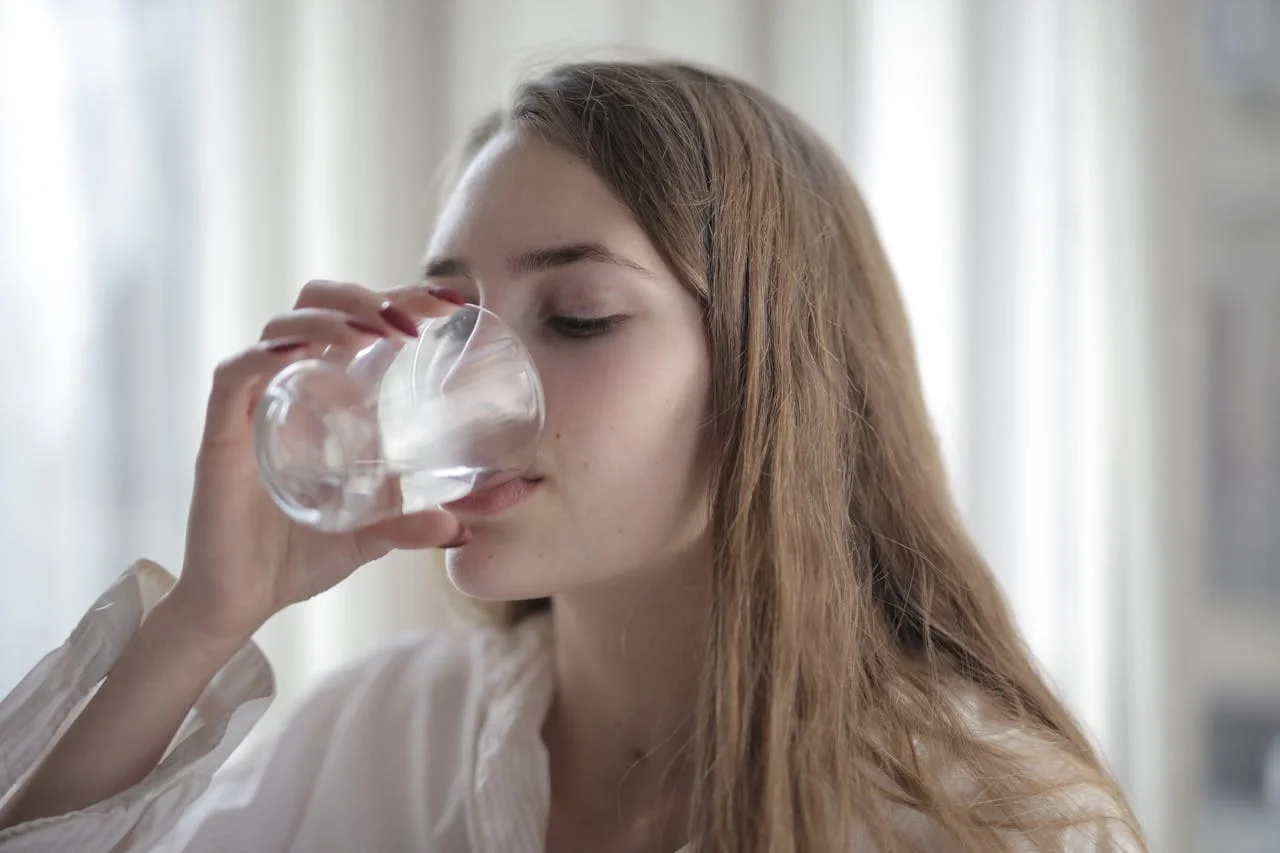 Imagen de una mujer bebiendo agua.