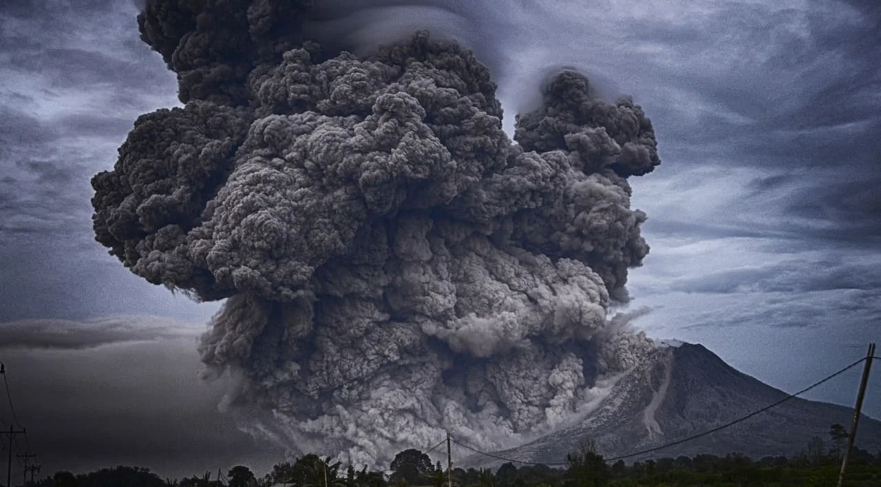 Erupción volcánica con una gran nube de cenizas.