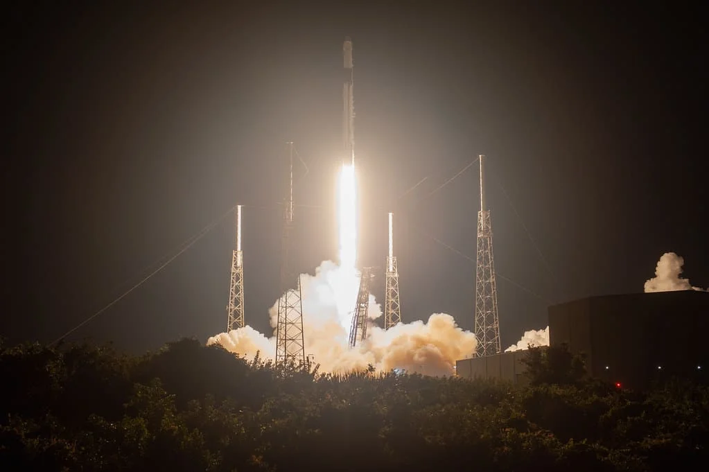 Lanzamiento nocturno de un cohete SpaceX Falcon 9 iluminando el cielo desde la Costa Espacial de Florida.
