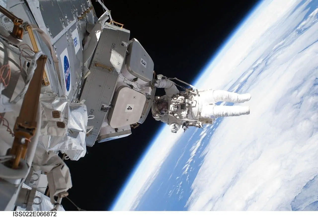 Astronauta de la NASA en un traje espacial, probando herramientas para recolección microbiana en el Laboratorio de Flotabilidad Neutral.