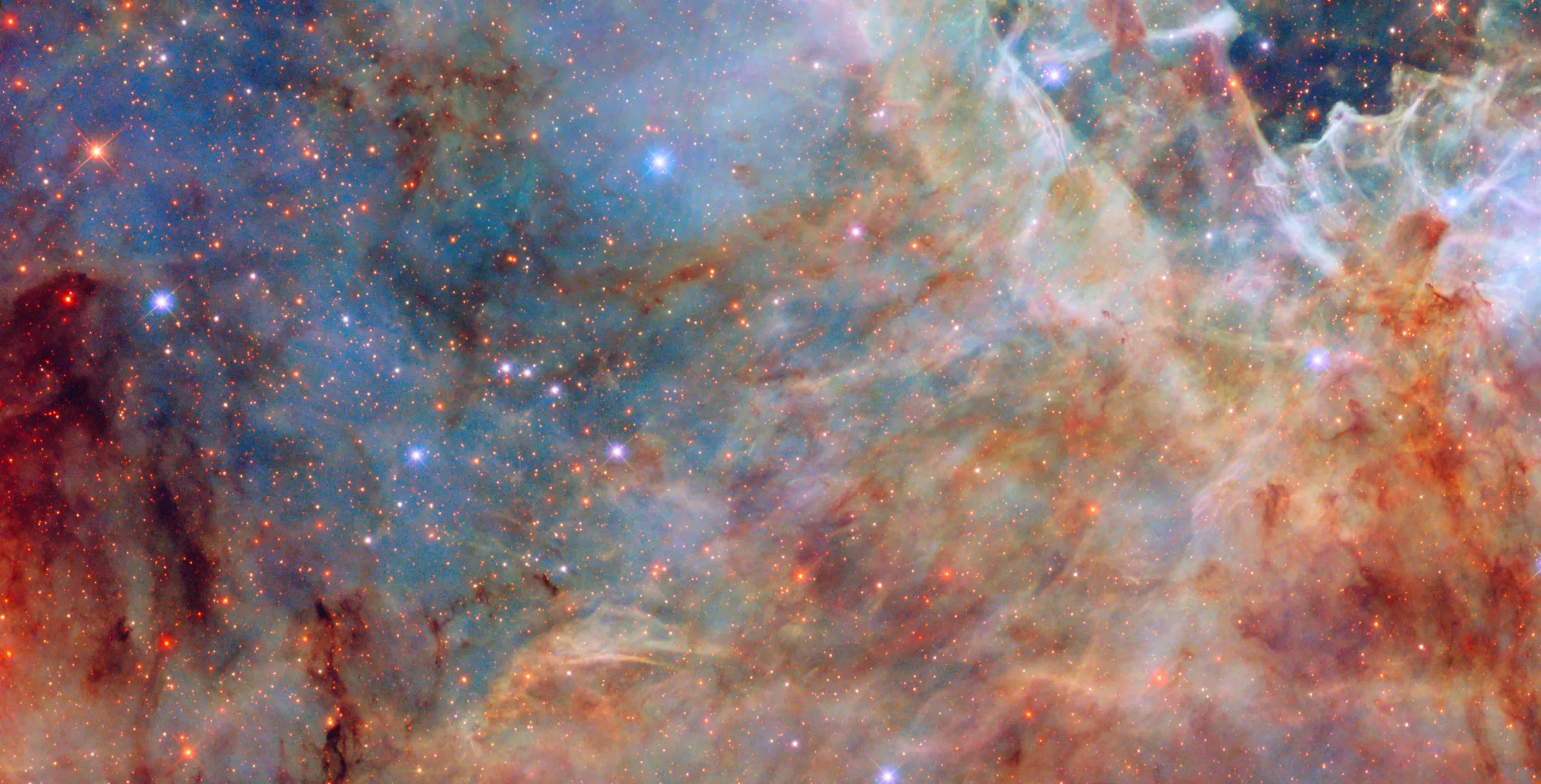 Región de la Nebulosa de la Tarántula observada por el Hubble, mostrando nubes de gas azul, estrellas brillantes y zonas polvorientas.