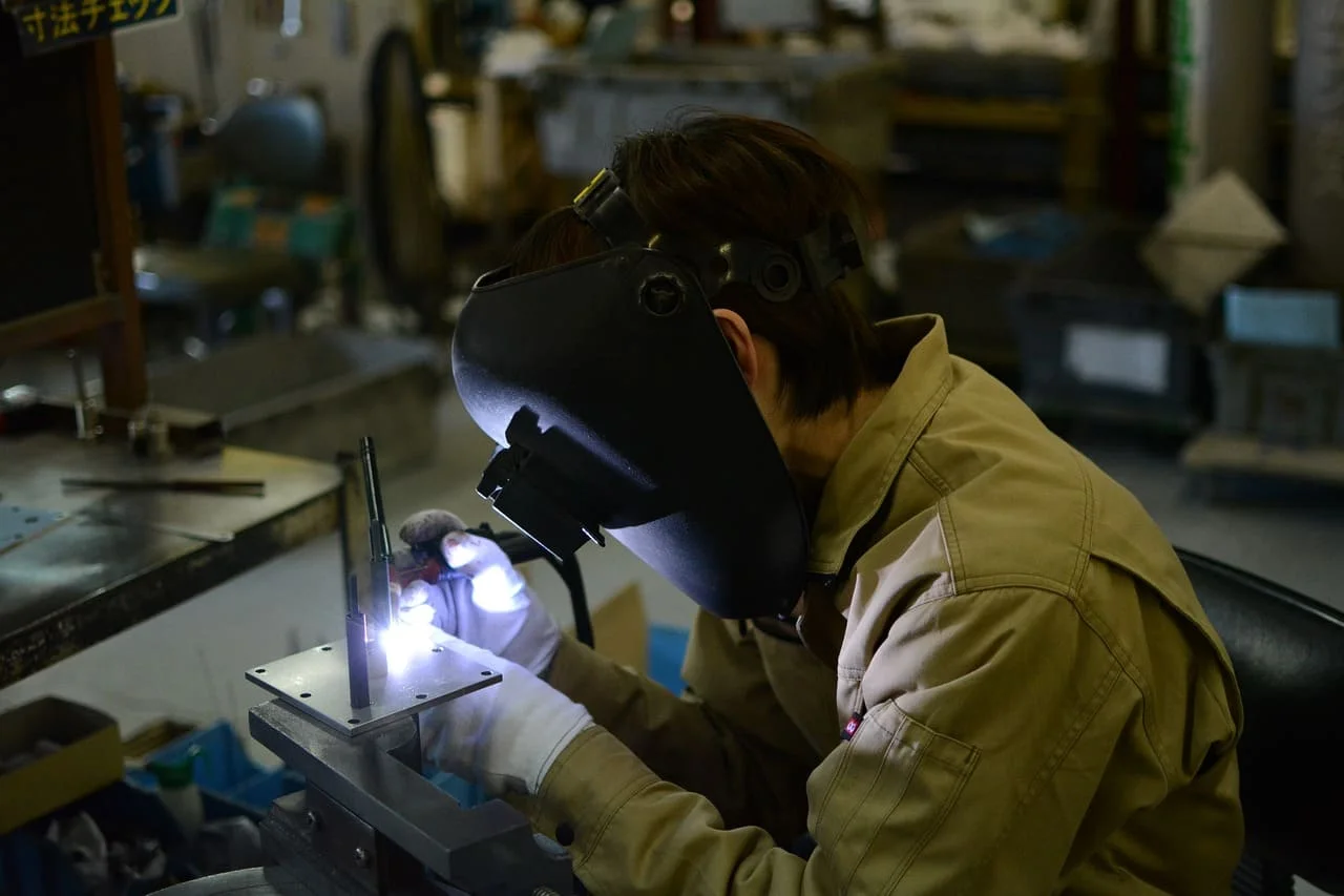 Trabajador realizando soldadura en fábrica asiática