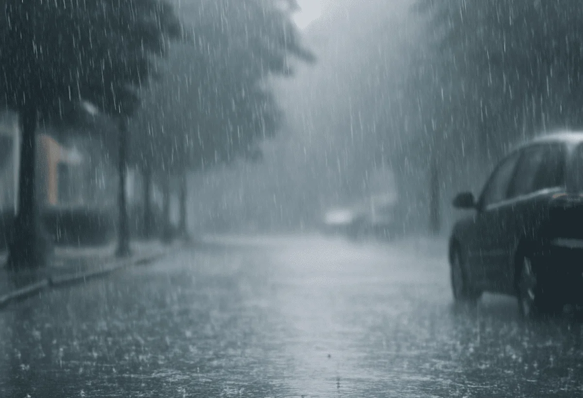 Lluvia intensa cayendo sobre una calle urbana con autos