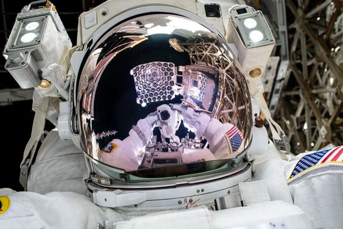 Reflejo del telescopio NICER en la visera del casco de un astronauta de la NASA