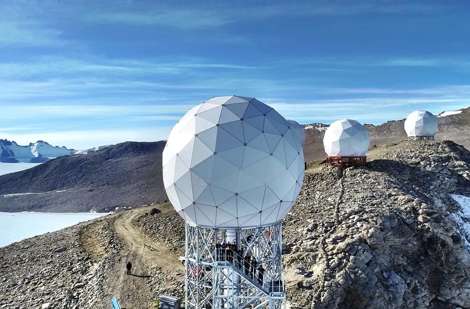 Antenas geodésicas de la estación terrestre Troll en un paisaje montañoso antártico
