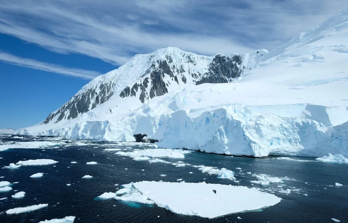 Cordillera cubierta de hielo y témpanos en la costa antártica