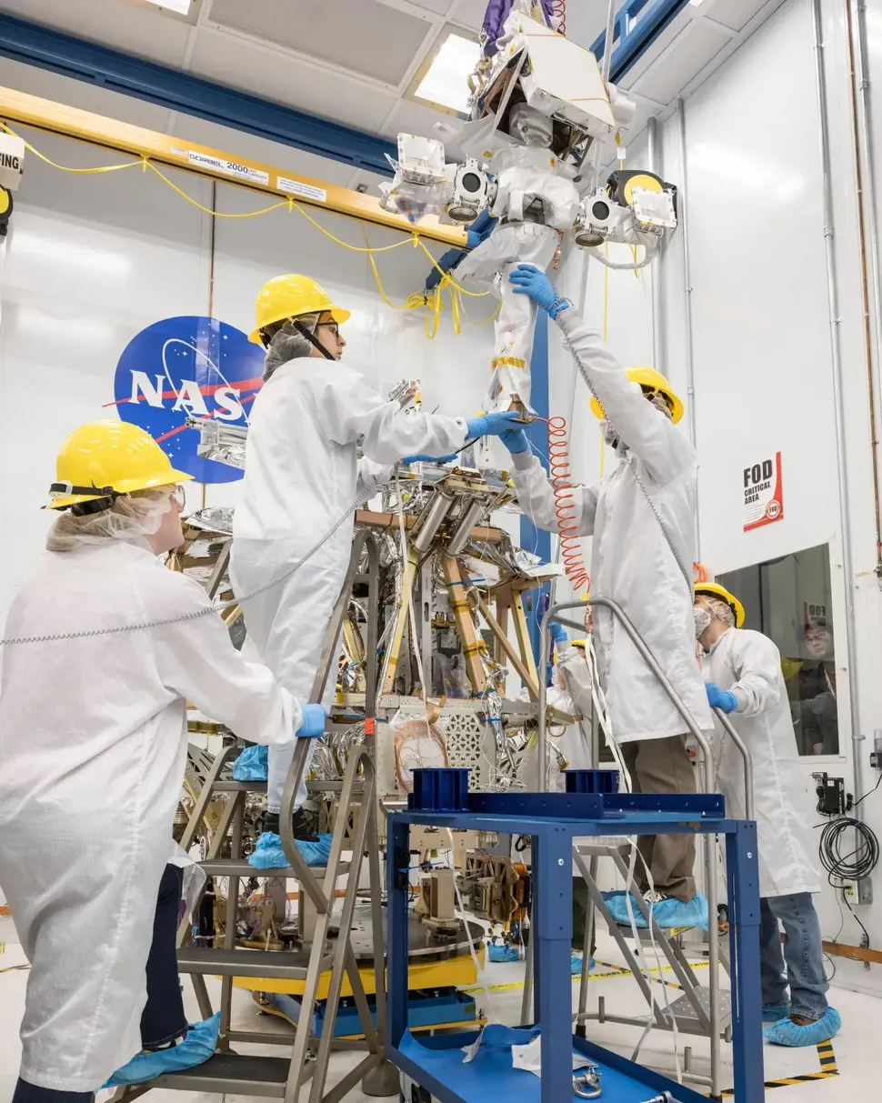 Técnicos ensamblando el rover VIPER en una sala limpia con equipo de protección
