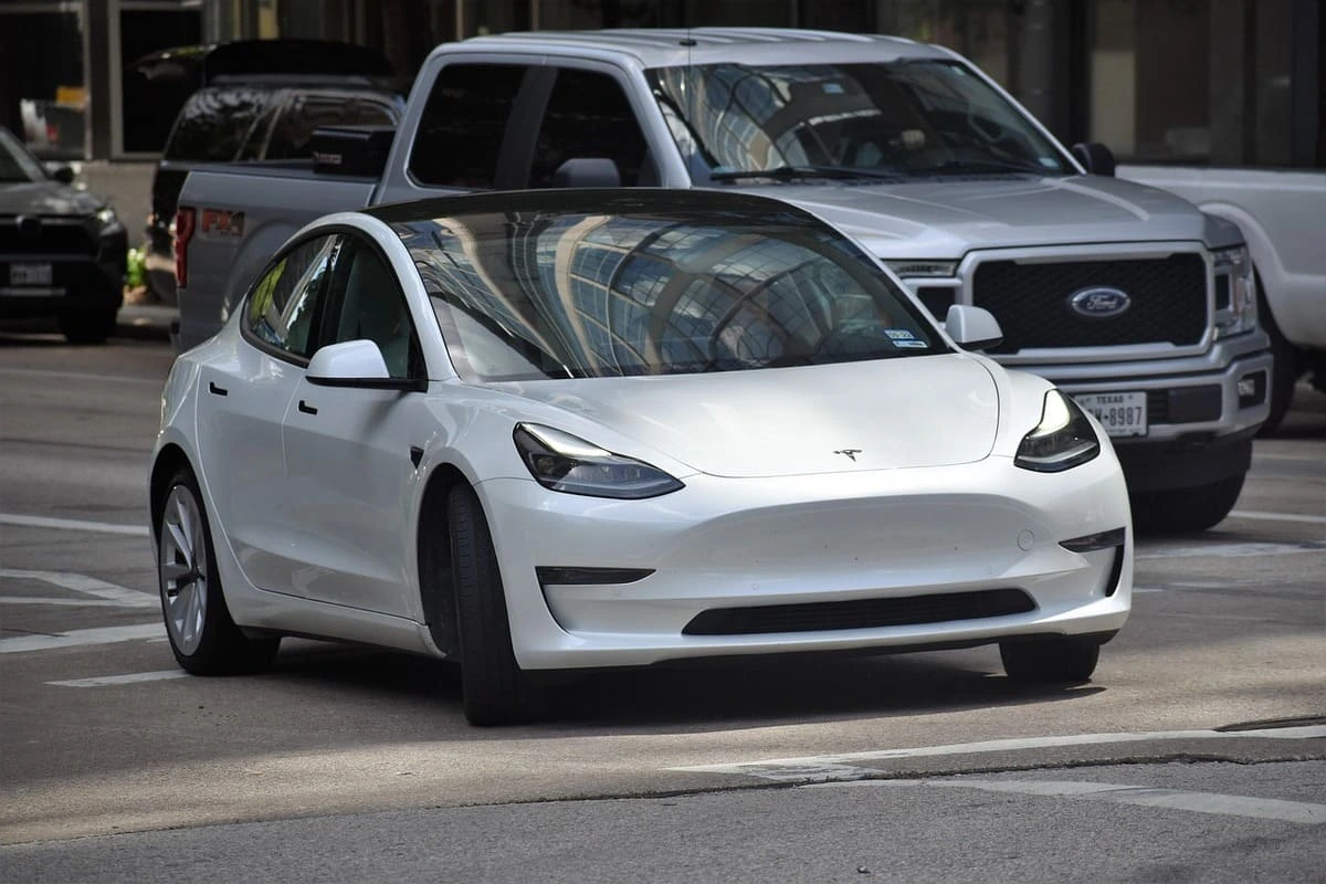 Vehículo eléctrico Tesla Model 3 en circulación urbana durante el día