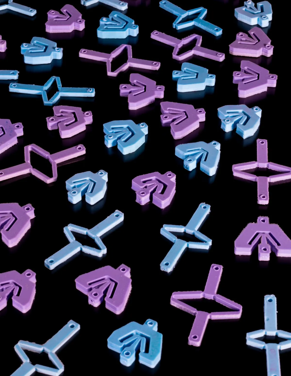 Varias piezas del material de contragolpe en colores azul y violeta dispuestas sobre superficie negra