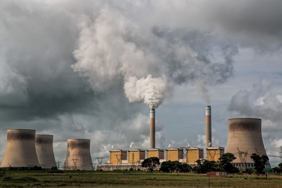 Central eléctrica emitiendo grandes cantidades de humo al cielo, símbolo de smog y cambio climático
