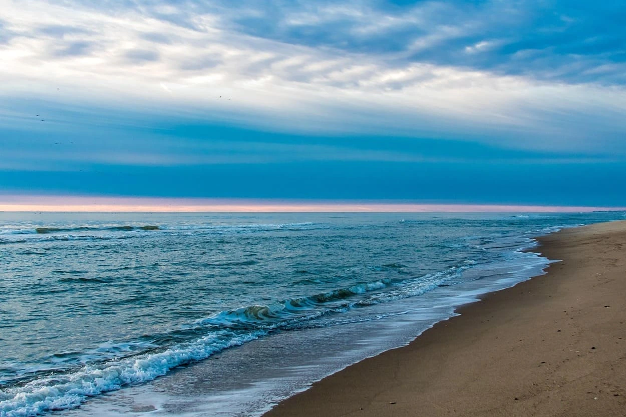 Playa desierta bajo un cielo azul al amanece