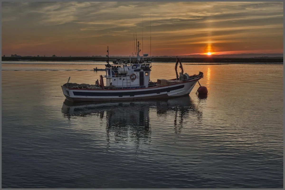 Barco de pesca en el mar al atardecer