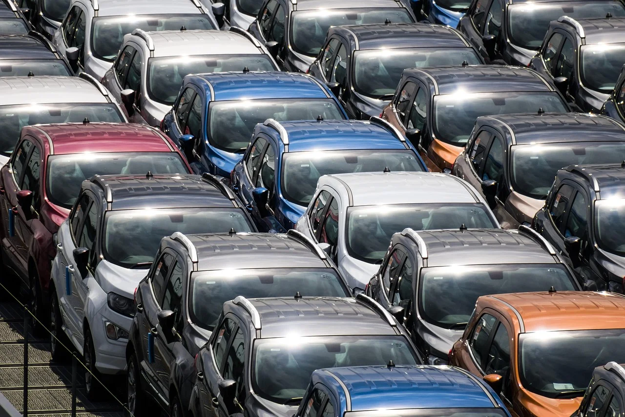 Vehículos nuevos estacionados en fila, reflejando el impacto de las restricciones chinas a las tierras raras en la industria automotriz