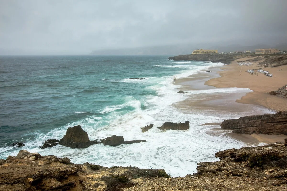 Costa atlántica con olas rompiendo en la playa bajo un cielo nublado