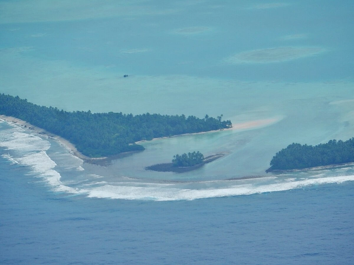 Vista aérea de Funafuti, capital de Tuvalu, donde la estrecha franja de tierra y el arrecife coralino rodean lagunas poco profundas, conformando un atolón vulnerable.
