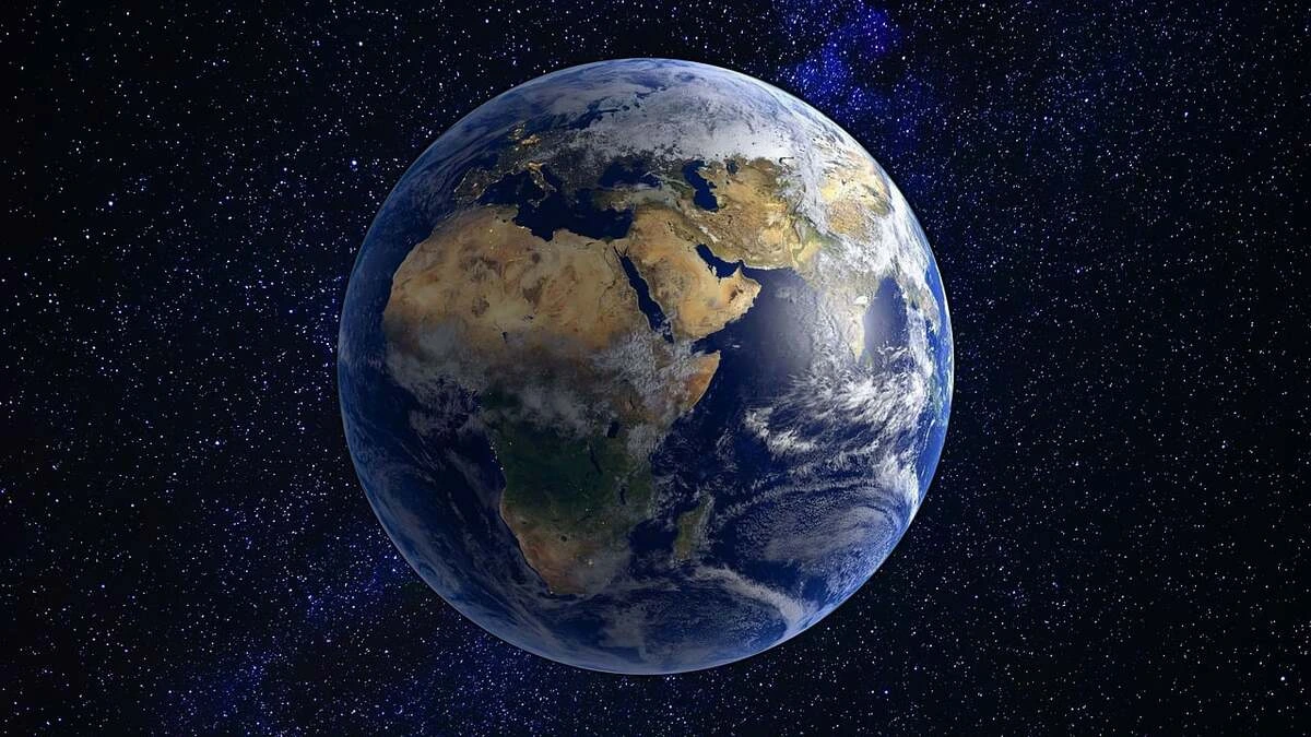 La Tierra vista desde el espacio, rodeada de estrellas, con África, Europa y Asia claramente visibles.