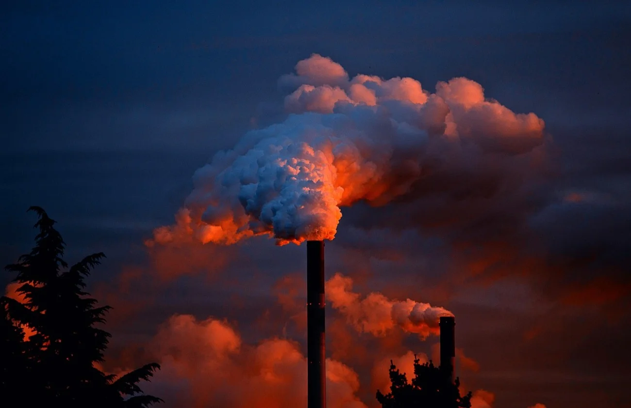 Chimeneas industriales emitiendo nubes de humo
