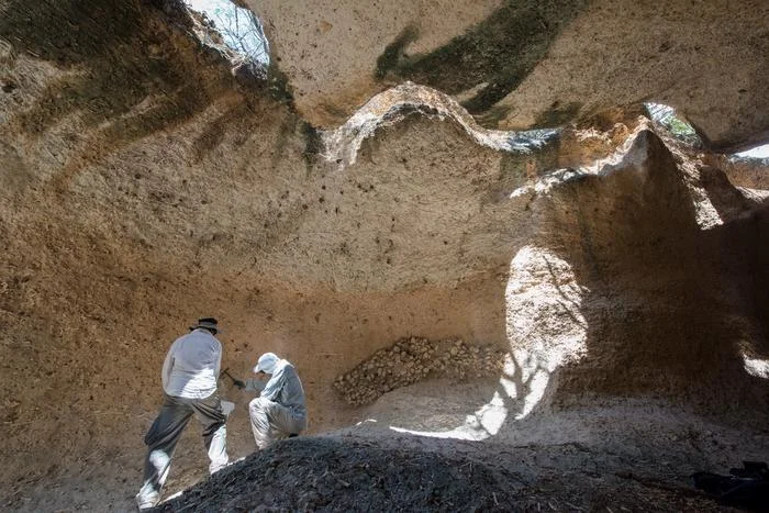 Dos científicos examinan formaciones de arrecife fosilizado en una caverna en República Dominicana.