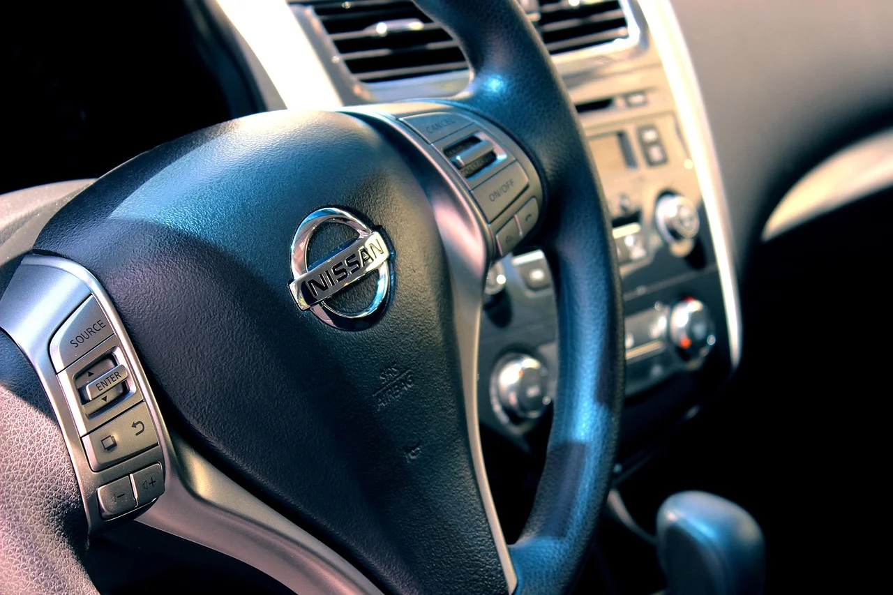 Mano en el volante y un móvil mostrando mensajes de WhatsApp
