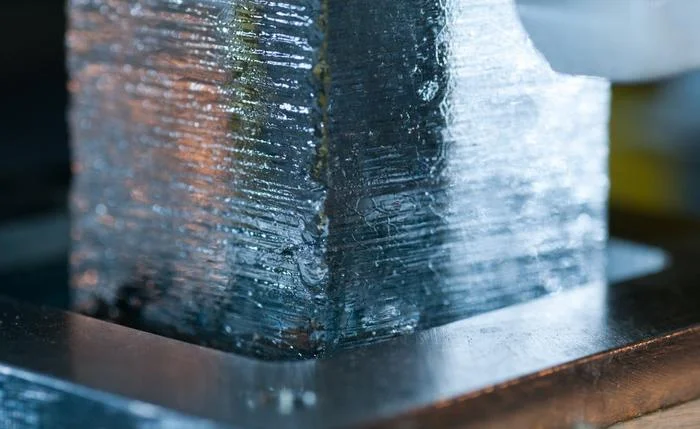 Muestra de hielo introducida en un horno de fusión durante análisis químicos continuos en laboratorio, con instrumentos científicos alrededor.