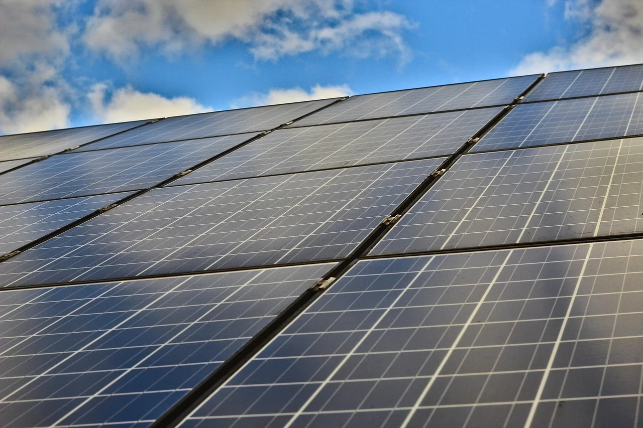 Paneles solares modernos instalados al aire libre bajo un cielo azul con algunas nubes
