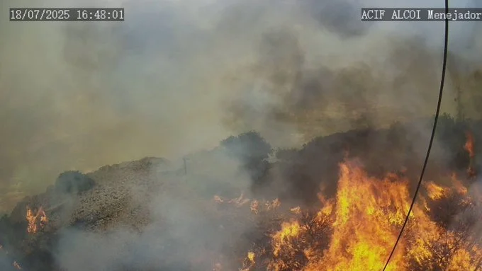 Incendio forestal con llamas y humo denso en la sierra, captado cerca de Ibi por cámara de vigilancia.