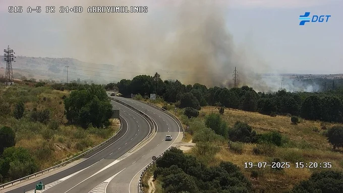 Columna de humo por incsendio forestal en Arroyomolinos, Madrid, vista desde la A-5, con carretera cortada y vegetación afectada