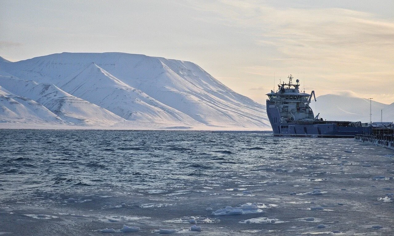 Barco amarrado junto a un muelle en las costas nevadas de Svalbard, Noruega